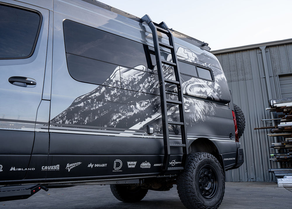 Side profile view from bottom to top of the ROAMBUILT Flatpack Ladder mounted on a Mercedes Sprinter, looking upward to show full height and attachment points.