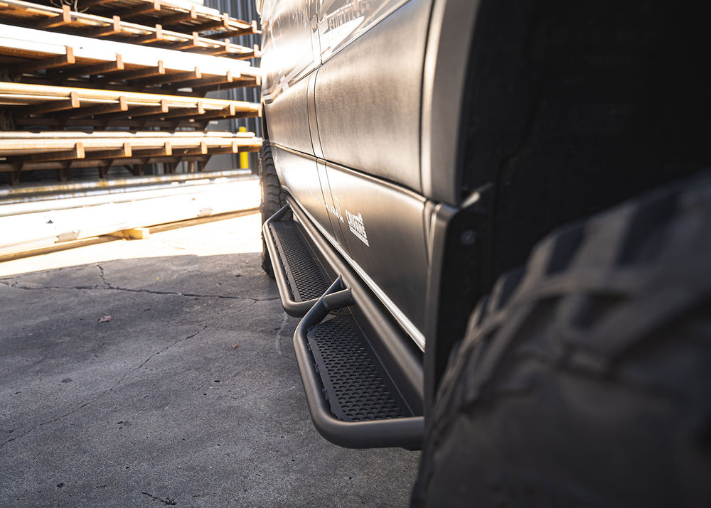 Top-down view of ROAMBUILT Passenger Side Tube Step on Mercedes Sprinter, showing perforated aluminum decking and tubular frame from front to back.