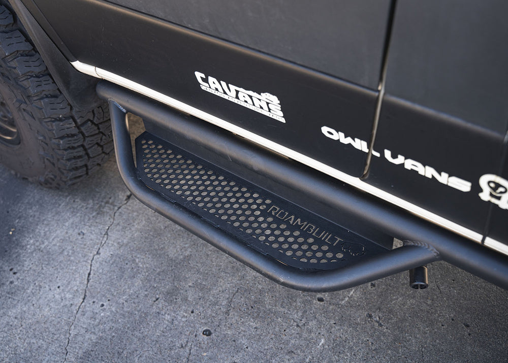Top-down view of the ROAMBUILT Mercedes Sprinter Side Step, showcasing the perforated step surface and prominently displayed ROAMBUILT logo.