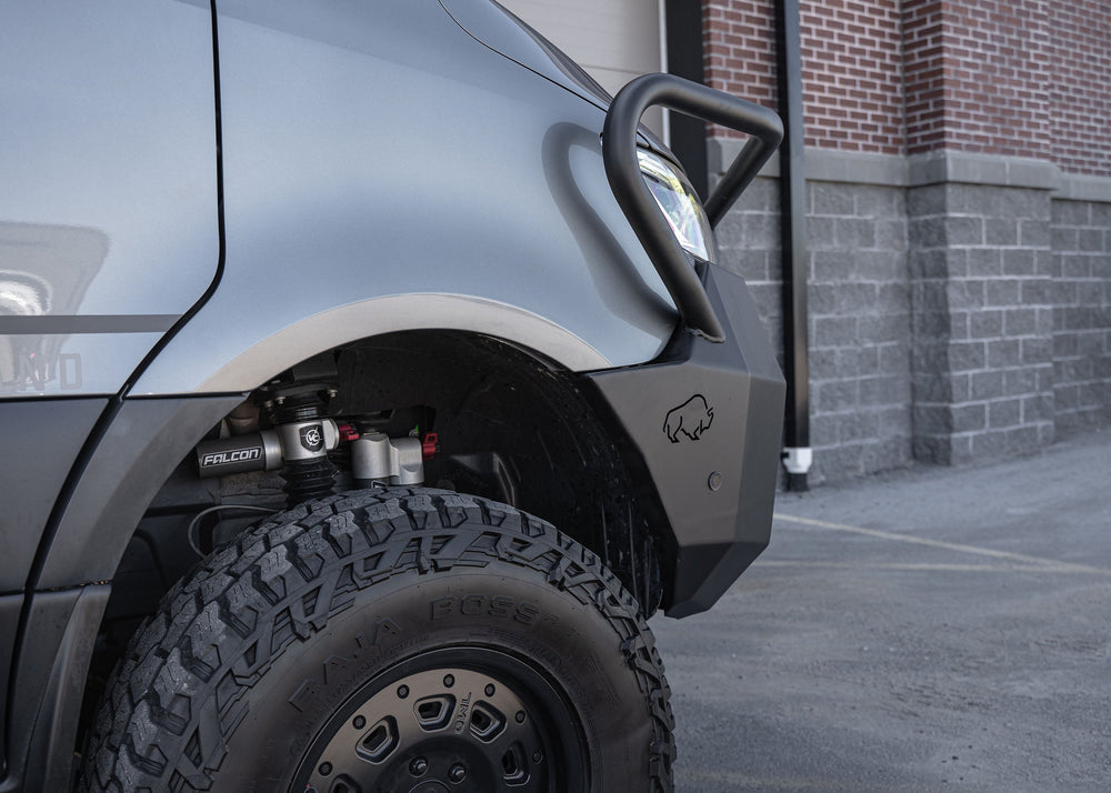 Side view of ROAMBUILT Full Guard Front Bumper on a Mercedes Sprinter, looking from the back, showing hybrid steel-aluminum construction and full wrap-around design.