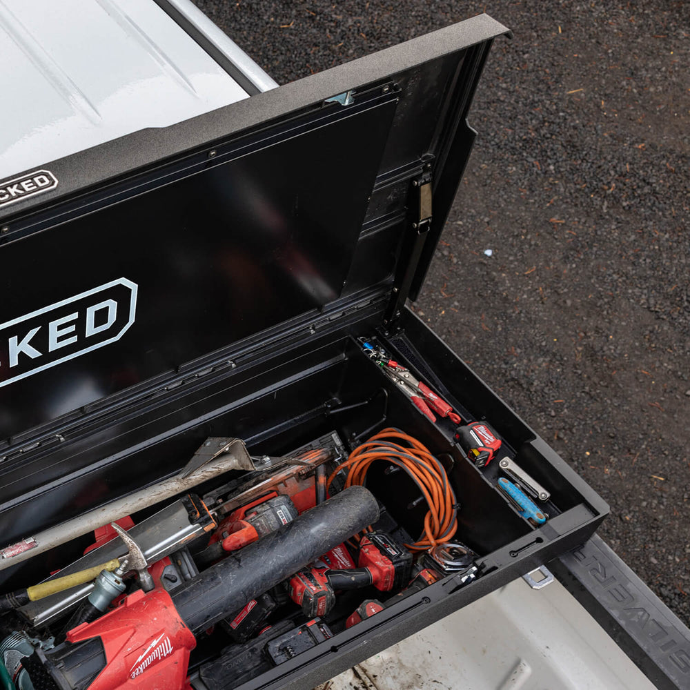 An open black DECKED Toolbox loaded with tools. 